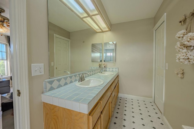 22633 Inspiration Pt, Canyon Lake, CA 92587 - bathroom with a sink, baseboards, double vanity, and tile patterned floors