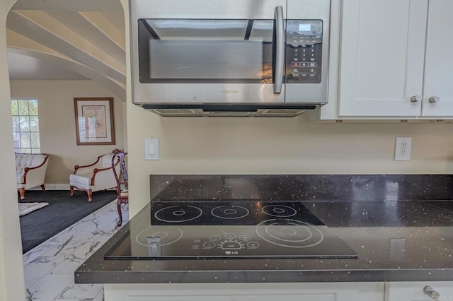 22633 Inspiration Pt, Canyon Lake, CA 92587 - kitchen featuring stainless steel microwave, baseboards, black electric stovetop, marble finish floor, and white cabinetry