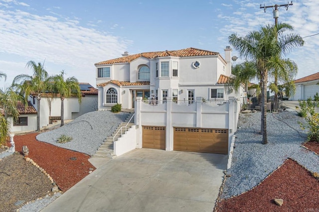 mediterranean / spanish-style house with stucco siding, stairway, concrete driveway, a garage, and a chimney