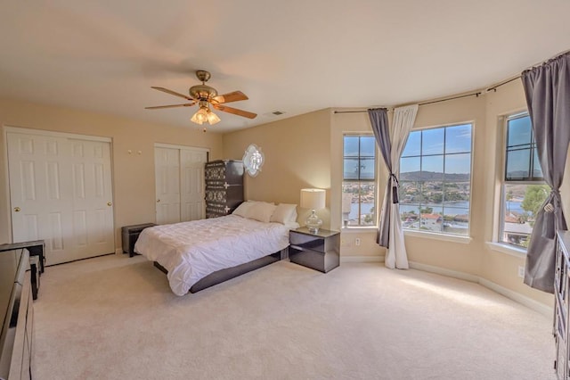 22633 Inspiration Pt, Canyon Lake, CA 92587 - carpeted bedroom with multiple closets, baseboards, visible vents, and ceiling fan