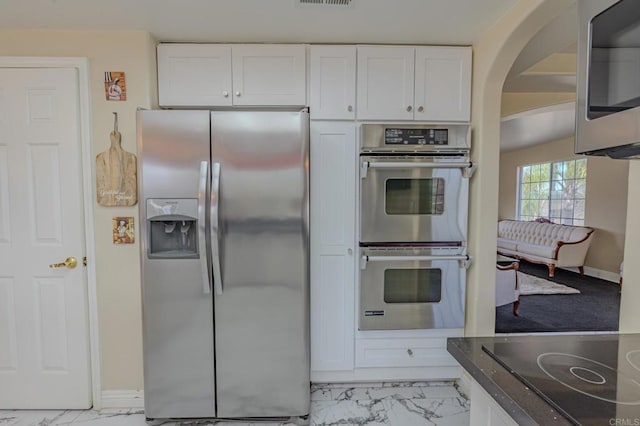 22633 Inspiration Pt, Canyon Lake, CA 92587 - kitchen featuring visible vents, appliances with stainless steel finishes, arched walkways, marble finish floor, and white cabinetry
