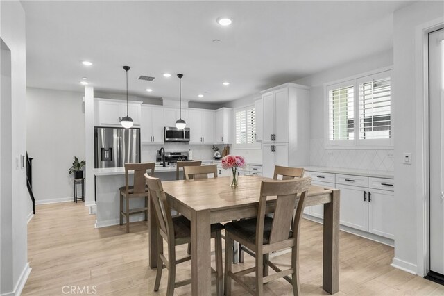 dining space with recessed lighting, baseboards, and light wood-style floors