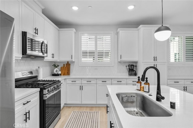 kitchen featuring a sink, white cabinetry, appliances with stainless steel finishes, and light countertops