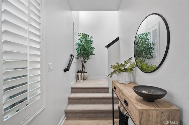 stairway with wood finished floors and baseboards