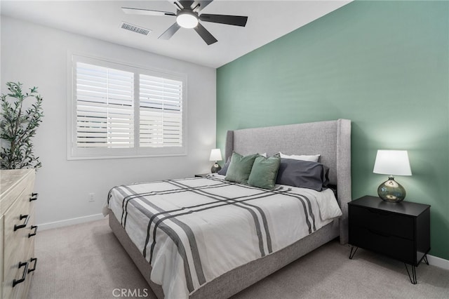 bedroom featuring a ceiling fan, light colored carpet, visible vents, and baseboards