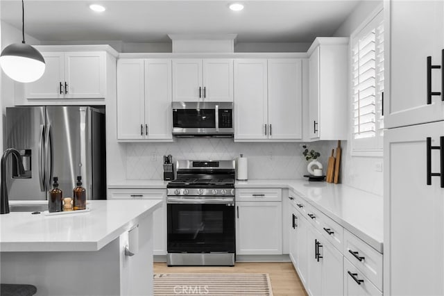 kitchen with white cabinetry, light countertops, backsplash, and stainless steel appliances