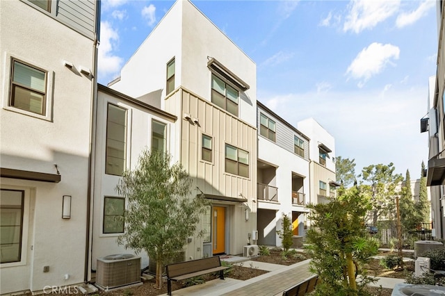 view of building exterior featuring a residential view and central AC