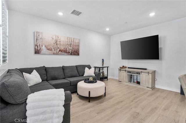 living room with recessed lighting, visible vents, baseboards, and light wood-style flooring