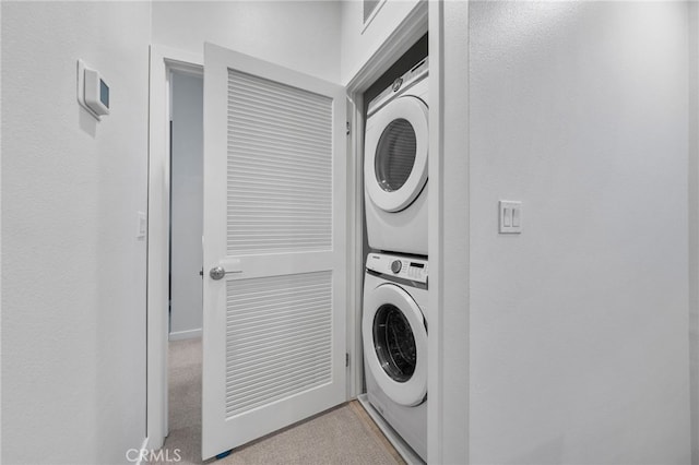 washroom featuring visible vents, stacked washer and dryer, and laundry area