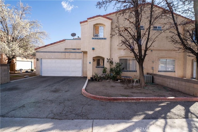 mediterranean / spanish-style home with stucco siding, a garage, and driveway