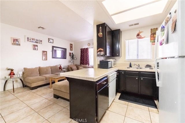 kitchen with visible vents, white appliances, open floor plan, and tile counters