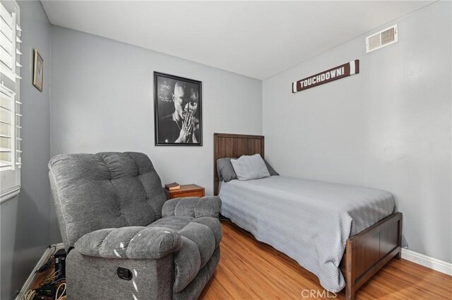 bedroom featuring light wood-style flooring, baseboards, and visible vents