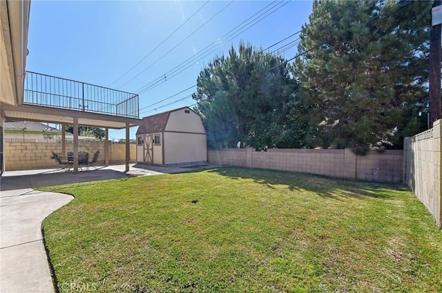 view of yard with an outbuilding, a fenced backyard, a shed, and a patio