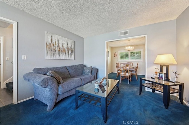 carpeted living area with visible vents, a textured ceiling, and an inviting chandelier