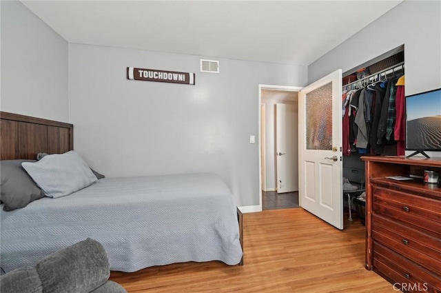 bedroom featuring a closet, visible vents, and wood finished floors