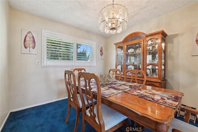 dining space with a notable chandelier, baseboards, carpet floors, and a textured ceiling