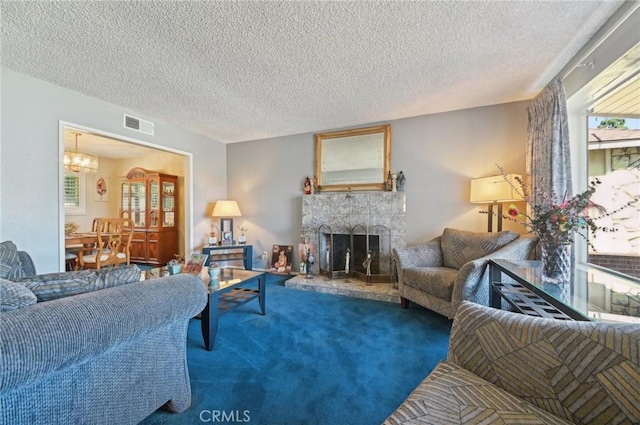 living area featuring visible vents, a textured ceiling, carpet, a fireplace, and a chandelier