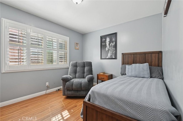 bedroom featuring light wood-style floors and baseboards