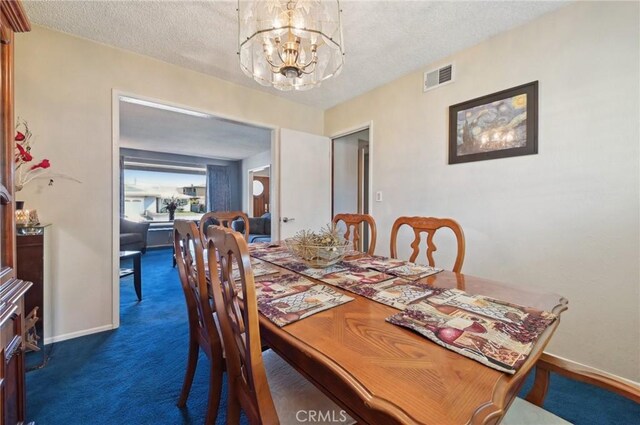 dining space with visible vents, baseboards, a chandelier, dark carpet, and a textured ceiling