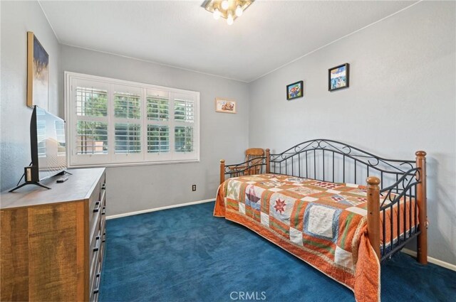 bedroom with baseboards and dark colored carpet