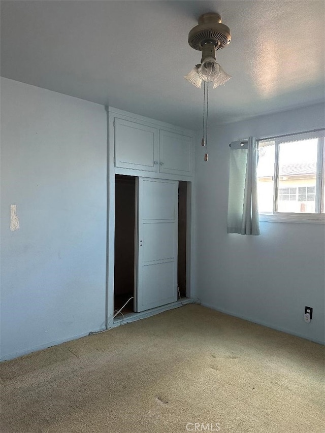 unfurnished bedroom featuring a closet and light colored carpet