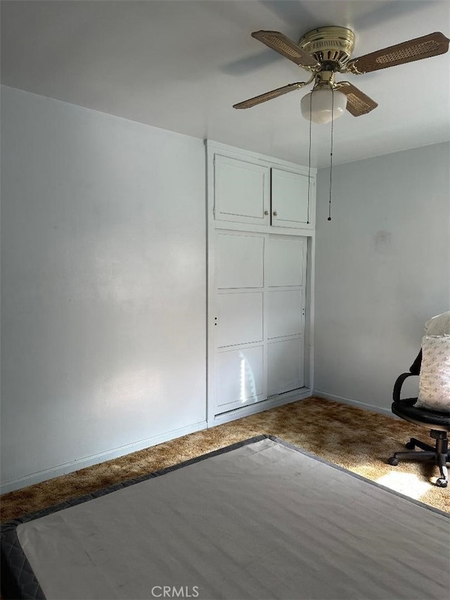 unfurnished bedroom featuring a closet, baseboards, and ceiling fan