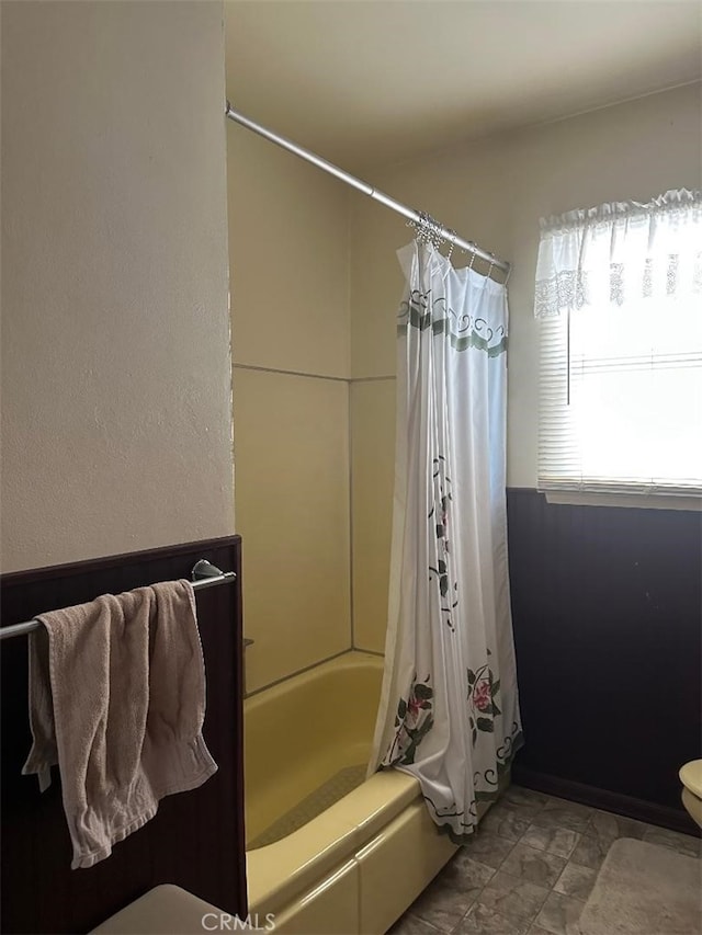 full bathroom featuring shower / bath combination with curtain and toilet