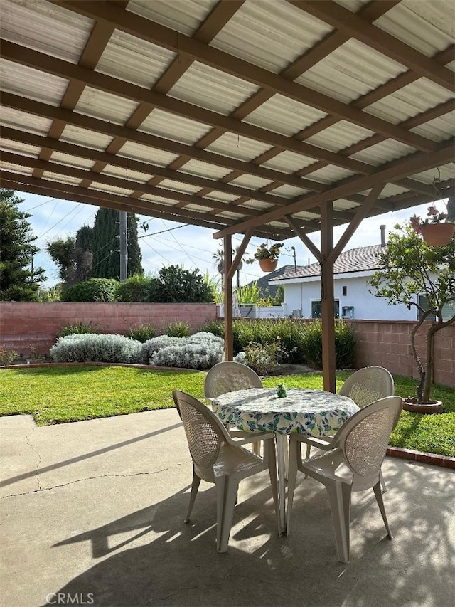 view of patio with outdoor dining space and fence