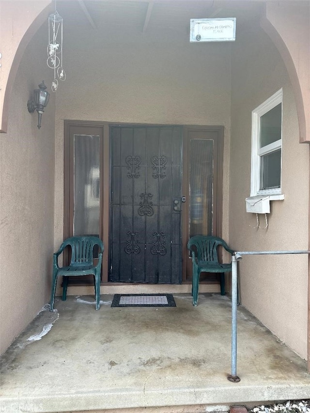 doorway to property featuring stucco siding