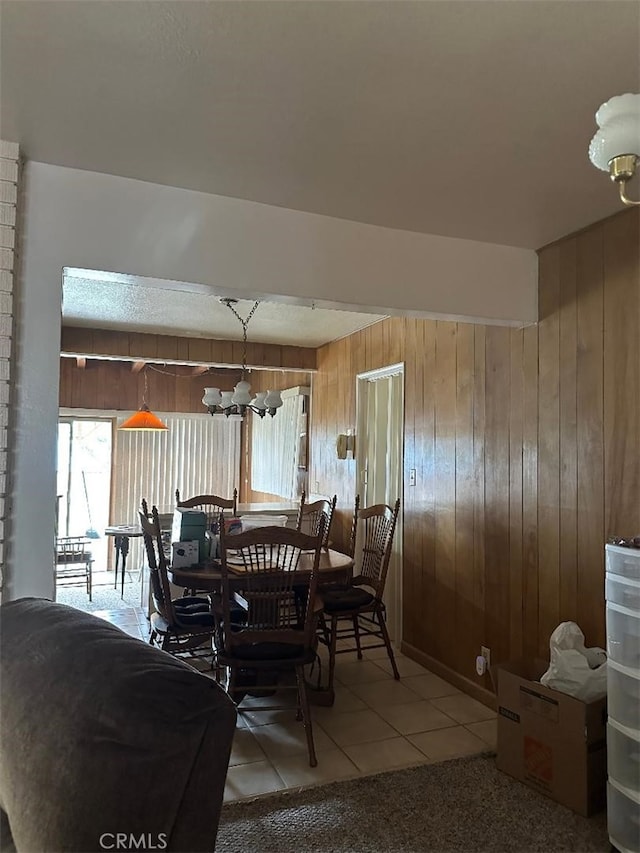 tiled dining space with a notable chandelier and wood walls