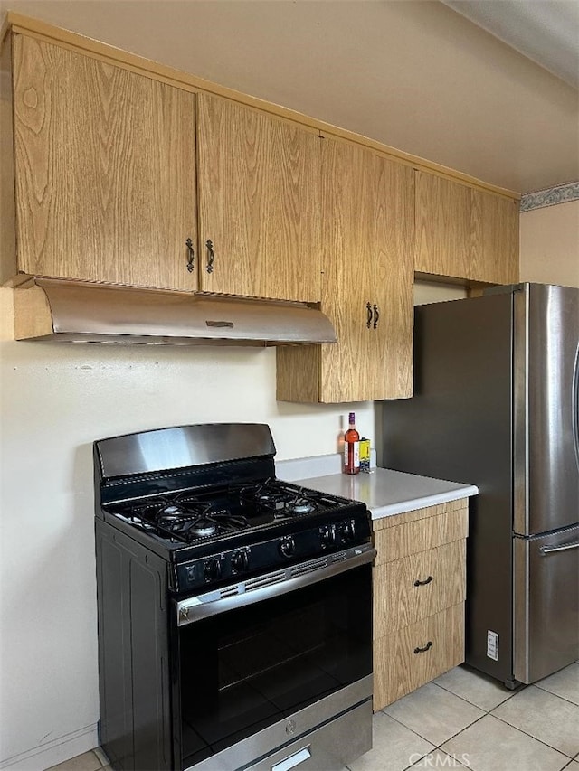 kitchen with under cabinet range hood, stainless steel appliances, light tile patterned flooring, and light countertops