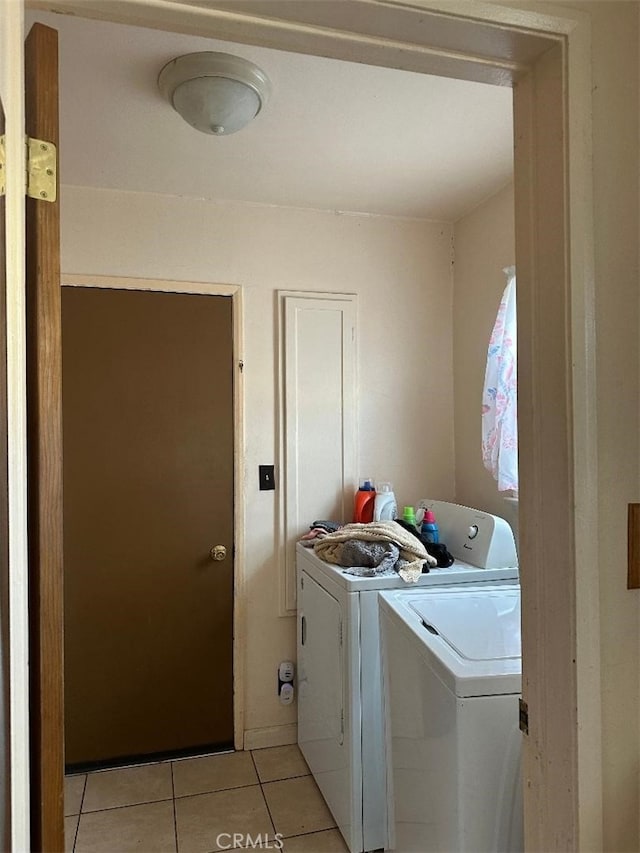 washroom with light tile patterned floors, laundry area, and independent washer and dryer