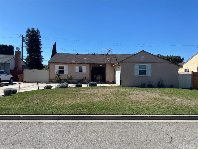 view of front of home with stucco siding, a front yard, a garage, and fence