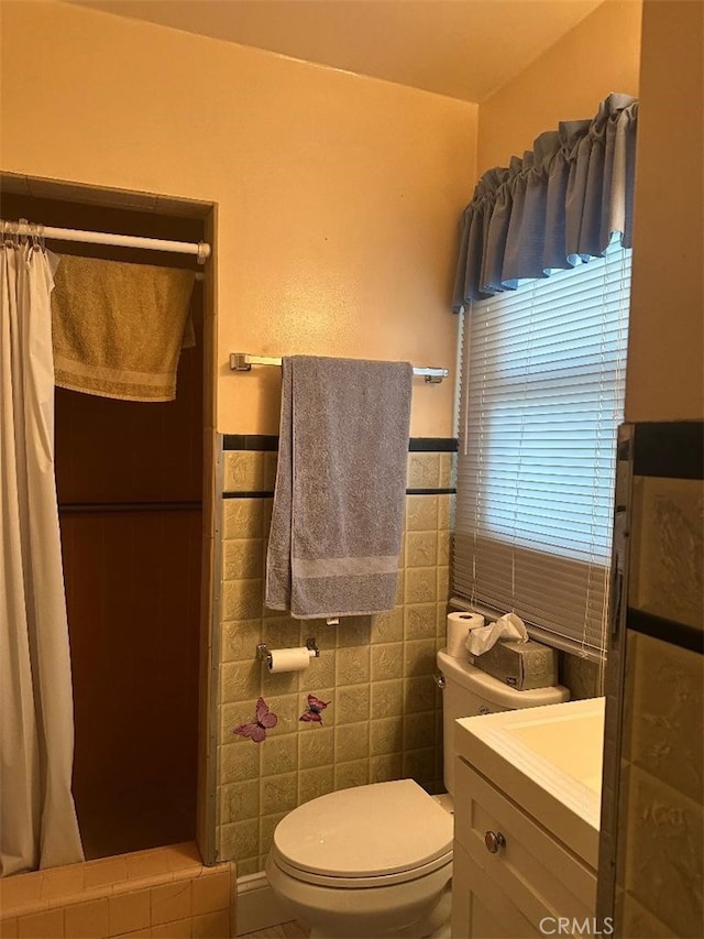 full bathroom with vanity, wainscoting, curtained shower, tile walls, and toilet