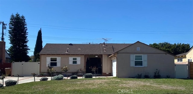 view of front of house with a front yard, a gate, an attached garage, and stucco siding