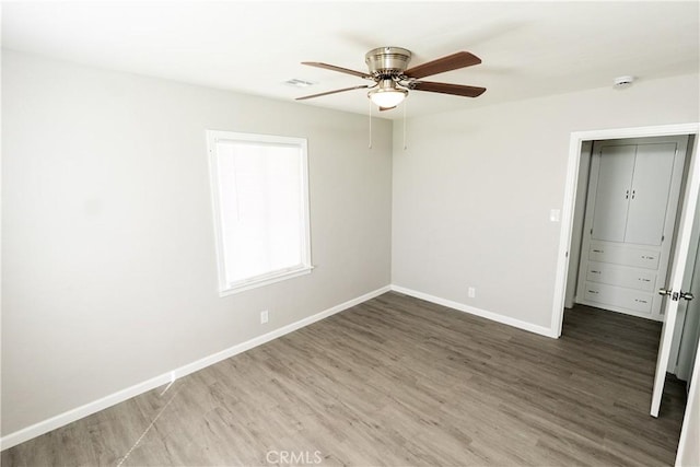 unfurnished bedroom with visible vents, wood finished floors, baseboards, and ceiling fan