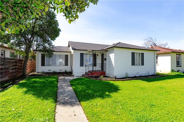 ranch-style house with a front yard and fence