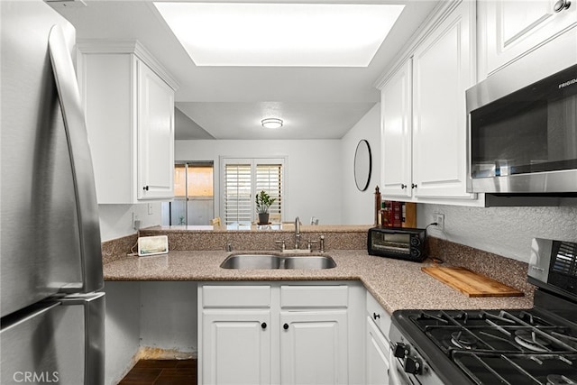 kitchen featuring white cabinetry, stainless steel appliances, and a sink