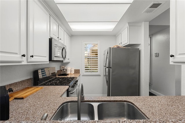 kitchen featuring white cabinetry, visible vents, appliances with stainless steel finishes, and a sink