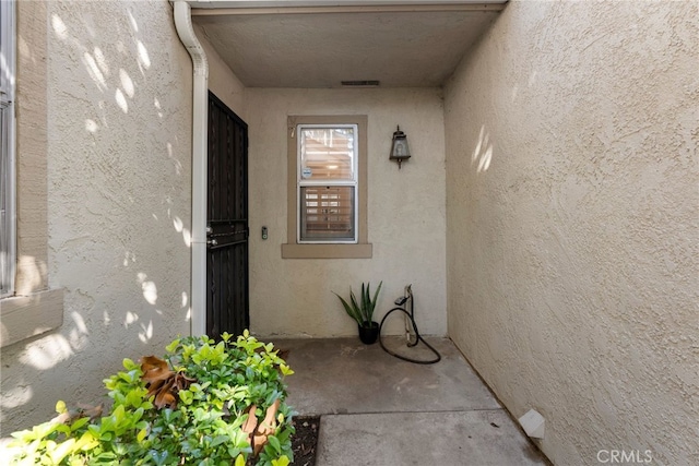 property entrance with stucco siding