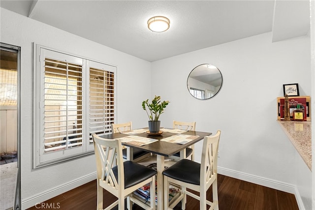 dining area with baseboards and wood finished floors