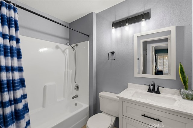 full bath featuring shower / tub combo, toilet, vanity, and a textured wall