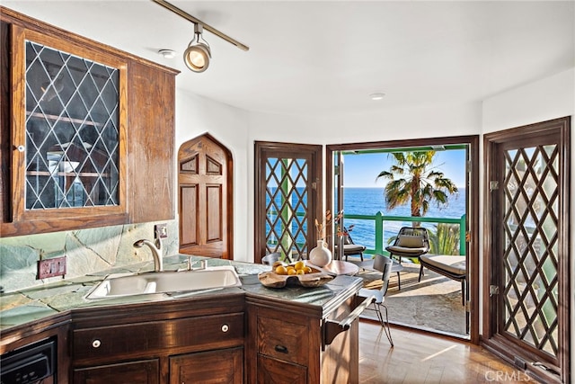kitchen with a sink, a water view, and wood finished floors