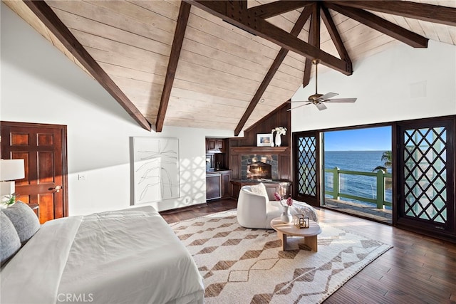 bedroom featuring beam ceiling, high vaulted ceiling, a warm lit fireplace, wooden ceiling, and a water view