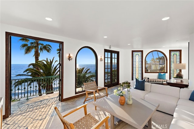 living room featuring a water view, recessed lighting, french doors, and baseboards