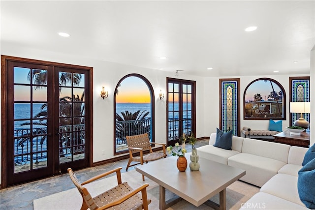 living area with french doors, recessed lighting, baseboards, and a water view
