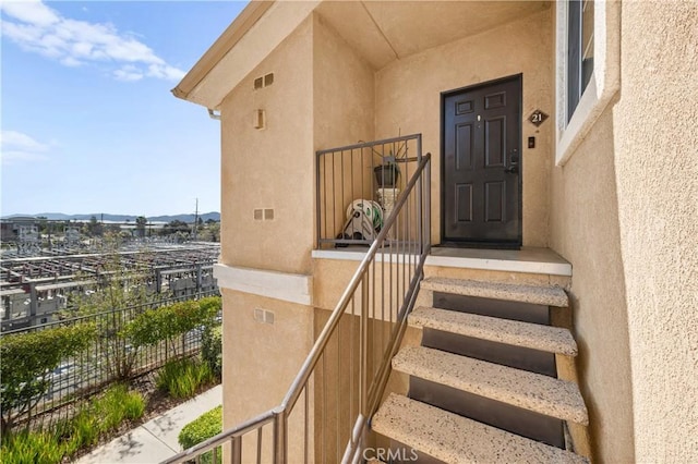 view of exterior entry featuring visible vents and stucco siding