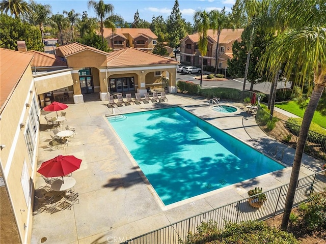 pool featuring a residential view, fence, a community hot tub, and a patio area