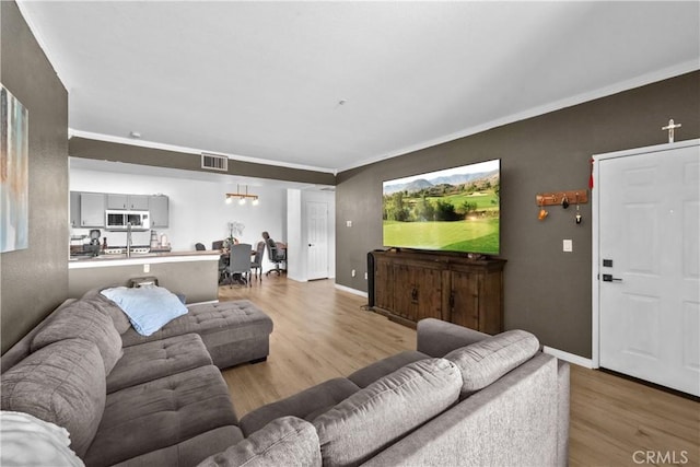 living room featuring visible vents, baseboards, and wood finished floors