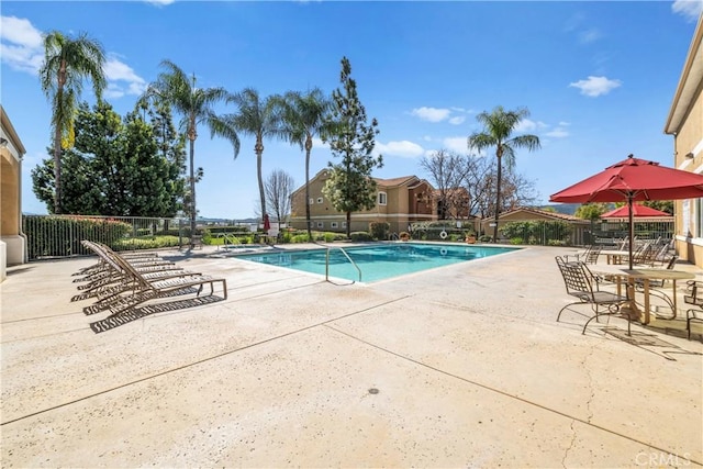 pool featuring fence and a patio area